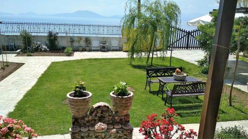 a garden with two potted plants and a table at Pelion Platanidia seaside house in Platanidia