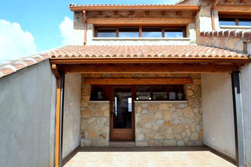 a stone house with a wooden entry door at El Carmen Fresa in Marlín