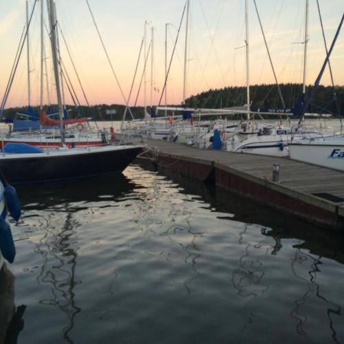a group of boats docked at a dock at Przytulisko na Mazurach in Ruciane-Nida