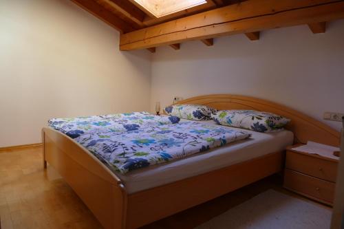 a bedroom with a bed with a wooden headboard and pillows at Haus Wiesenruh in Oberstdorf