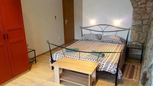 Schlafzimmer mit einem Bett und einem Holztisch in der Unterkunft Beach House Bassi in Rijeka