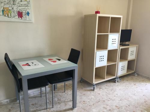 a table and two chairs and a book shelf at Estudio frente al mar in Ceuta