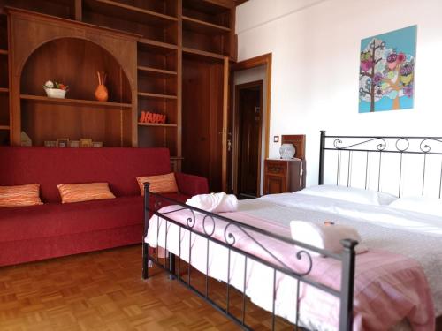 1 dormitorio con 1 cama y 1 sofá rojo en B&B Colombo, en Pisa