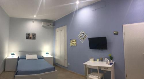 シラクーサにあるCasa Elenaの青い壁のベッドルーム(ベッド1台、デスク付)