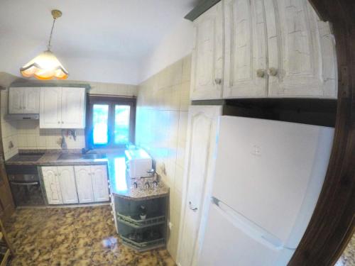 a kitchen with white cabinets and a white refrigerator at El Jardín de las Retamas in Vilaflor