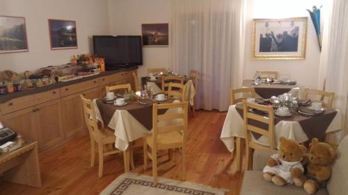 a dining room with two tables and a teddy bear at Il Cardo Trentino in Bedollo