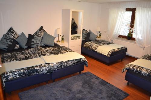 a bedroom with two beds and a mirror at Apartment Cosmelux Nürnberg in Nuremberg