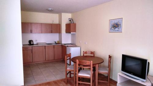a kitchen and dining room with a table and a television at Darius HSTL in Sunny Beach