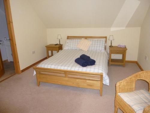 ein Schlafzimmer mit einem Bett mit blauem Hut darauf in der Unterkunft Goldenhill in Portree