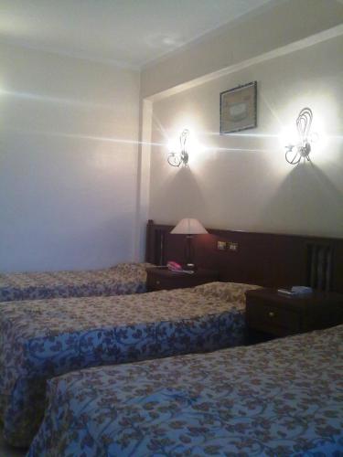 a hotel room with two beds and lights on the wall at Orchida St. George Hotel in Aswan
