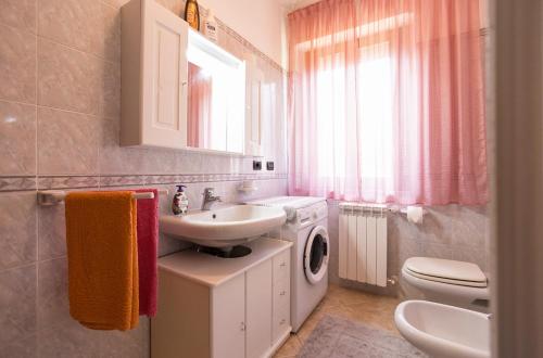 a bathroom with a sink and a washing machine at D&V Casa-Sea in Alghero