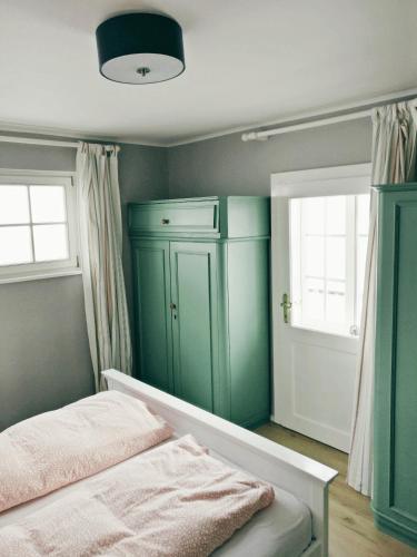 a bedroom with a green cabinet and a bed at Pension Edelweiss Top 25 in Gosau