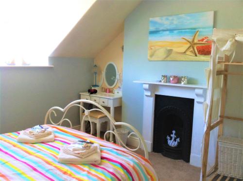a bedroom with a bed and a fire place at Happy Seaside Days in Combe Martin, Devon in Combe Martin