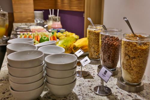 a table topped with plates and jars of food at Maringá Airport Hotel in Maringá