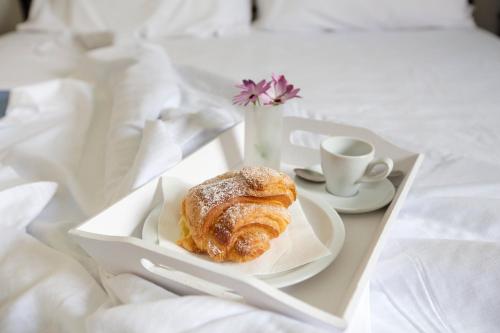 a tray with a pastry and a cup of coffee at Cala di Ponente in Castelluzzo