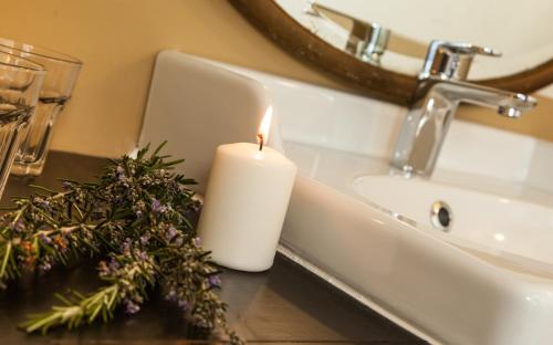 a candle sitting on a counter next to a sink at Il était une fois chez moi- La maison d'Eugénie in Le Loroux-Bottereau