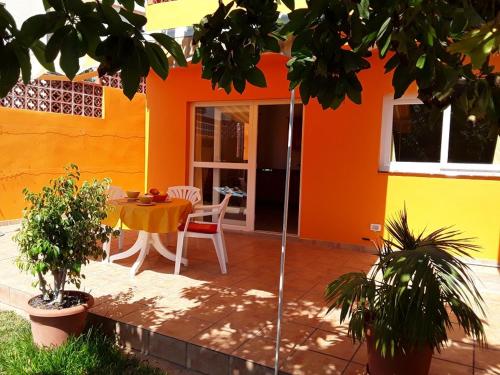 バジェ・グラン・レイにあるBungalow Heike 2 (Only Adults)の庭にテーブルと椅子があるオレンジハウスです。