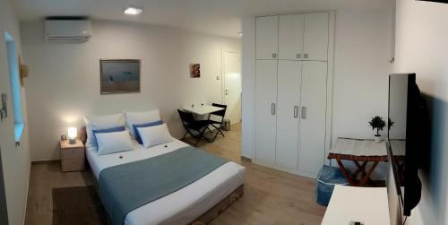 ein Schlafzimmer mit einem Bett, einem Tisch und einem Schreibtisch in der Unterkunft Villa Big Blue, Tisno in Tisno