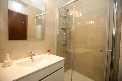 a bathroom with a sink and a shower at Casa da Alegria in Lagos
