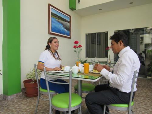 a man and a woman sitting at a table at Alojamiento El Cardenal in Iquitos