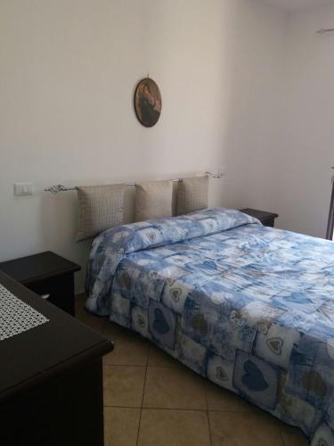 サン・ヴィート・ロ・カーポにあるAppartamento Ninoのベッドルーム1室(ベッド1台、壁掛け時計付)