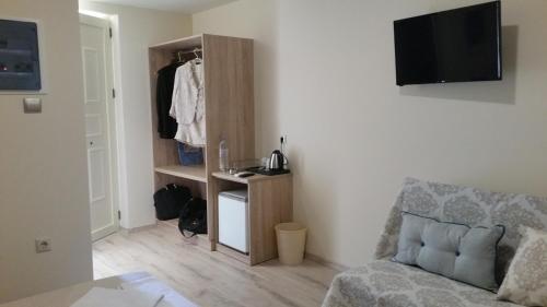 uma sala de estar com um sofá e um armário em Dreamy Airport's Apartment em Heraclião