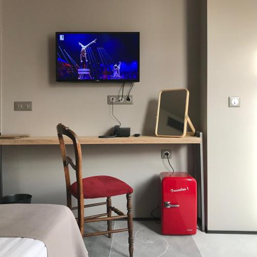a room with a desk with a television and a red suitcase at Design Hotel 36 in Sofia