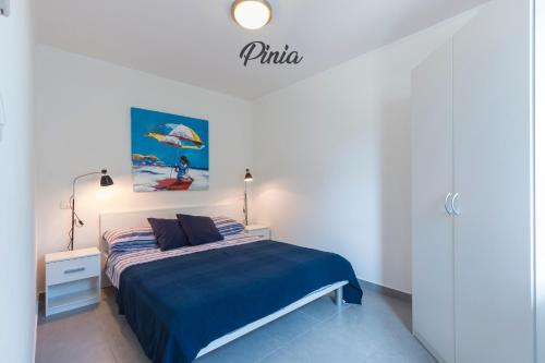a white bedroom with a bed with a blue blanket at Luxury Apartments Tramontana in Medulin
