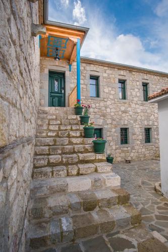 a stone building with stairs leading up to a door at Hotel Arhontiko Vourloka in Pramanta