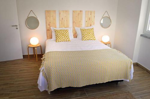 a bedroom with a large bed with two lamps at Alojamento Charme in Bombarral