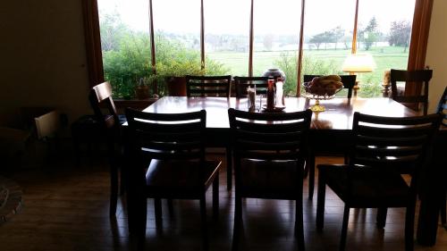 a dining room with a table and chairs and a large window at Pinecone Motel in Sussex