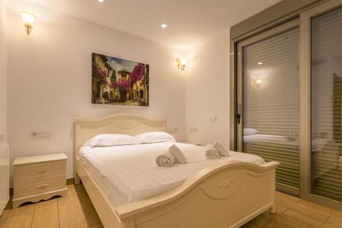 a bedroom with a large white bed and a window at Grand Palace in San Antonio Bay