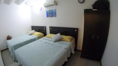 a bedroom with two beds and a dresser at Casa Arena San Andres in San Andrés