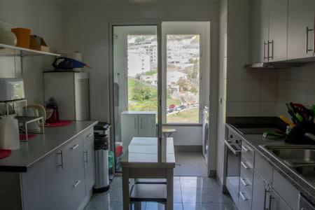 a kitchen with a table and chairs and a window at PERFECT DUPLEX PISCINE Zone VIP Funchal in Funchal