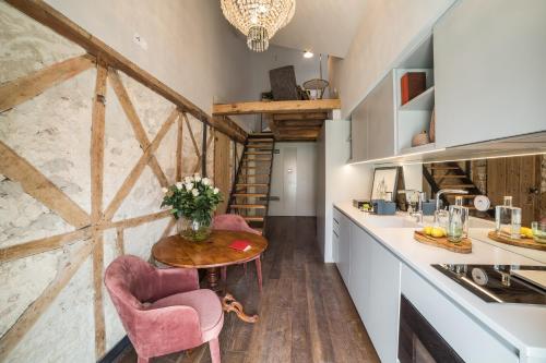 a kitchen with a table and two pink chairs at Dare Lisbon House in Lisbon