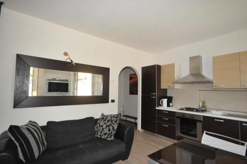 a living room with a black couch and a kitchen at VILLA VINICIA, pool, jacuzzi, airco in Domaso