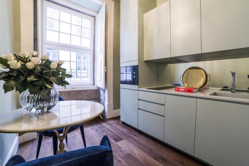 a kitchen with a table and a vase of flowers at Dare Lisbon House in Lisbon