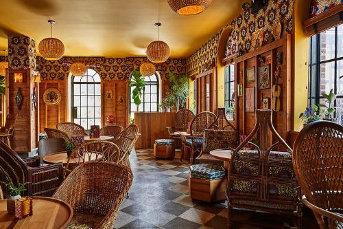 a restaurant with wicker chairs and tables and windows at Freehand New York in New York