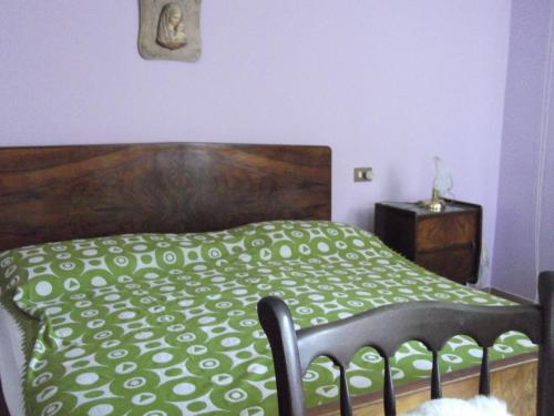 una camera con un letto con copriletto verde e bianco di La Panoramica a Perarolo