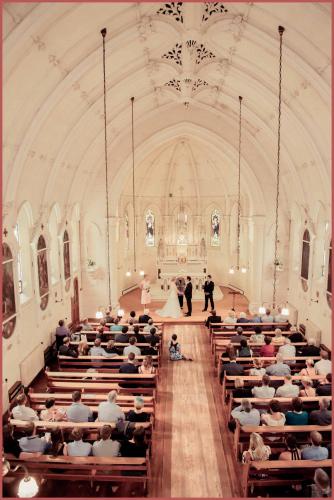 a bride and groom walking down the aisle in a church at Teschemakers Resort in Oamaru