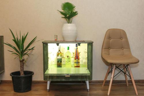 ein Aquarium mit Alkoholflaschen neben einem Stuhl in der Unterkunft SALOUNIQUE Lux Apartment in Tbilisi City