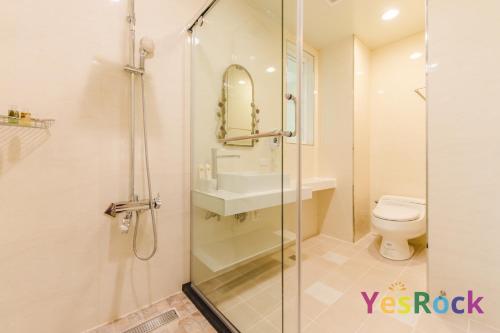 a bathroom with a shower and a sink and a toilet at 羅東微風小棧民宿 in Luodong