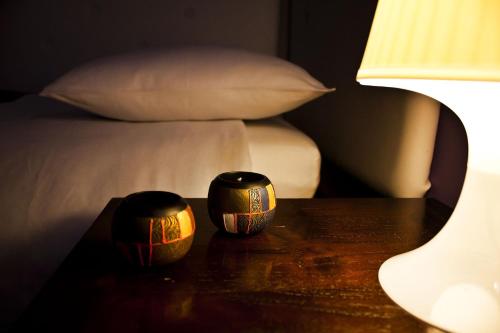 two vases sitting on a table next to a bed at Blu Mediterraneo B&B in Messina