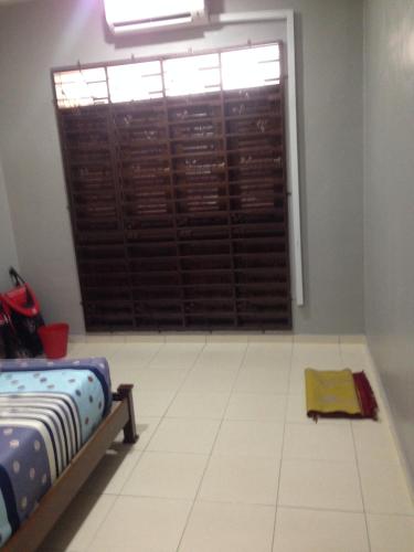 a room with a bed and a window with a door at TeratakMuslim H'H in Melaka