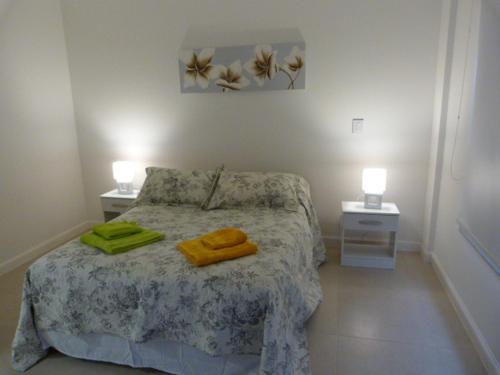 een slaapkamer met een bed met twee handdoeken erop bij Torre 1 Relax in Puerto Madryn