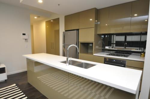 uma cozinha com um lavatório e um fogão em Orange Stay Sydney CBD em Sidney