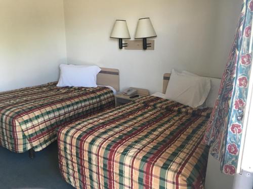 a hotel room with two beds and two lamps at America's Best value Inn & Suites-Helena in Helena