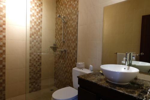 a bathroom with a sink and a toilet and a shower at Villa Celavi 77 in Jimbaran