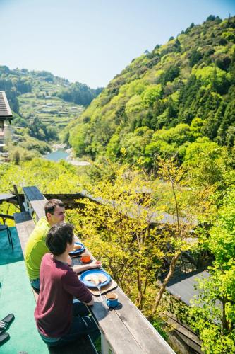 a man and a boy standing at a table with plates of food at Momonga Village in Miyoshi