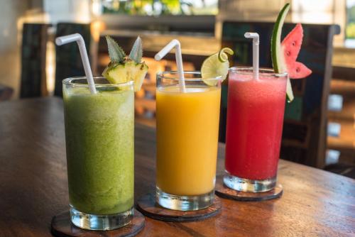 drie verschillende gekleurde dranken zittend op een tafel bij Green Sala Villa in Ubud